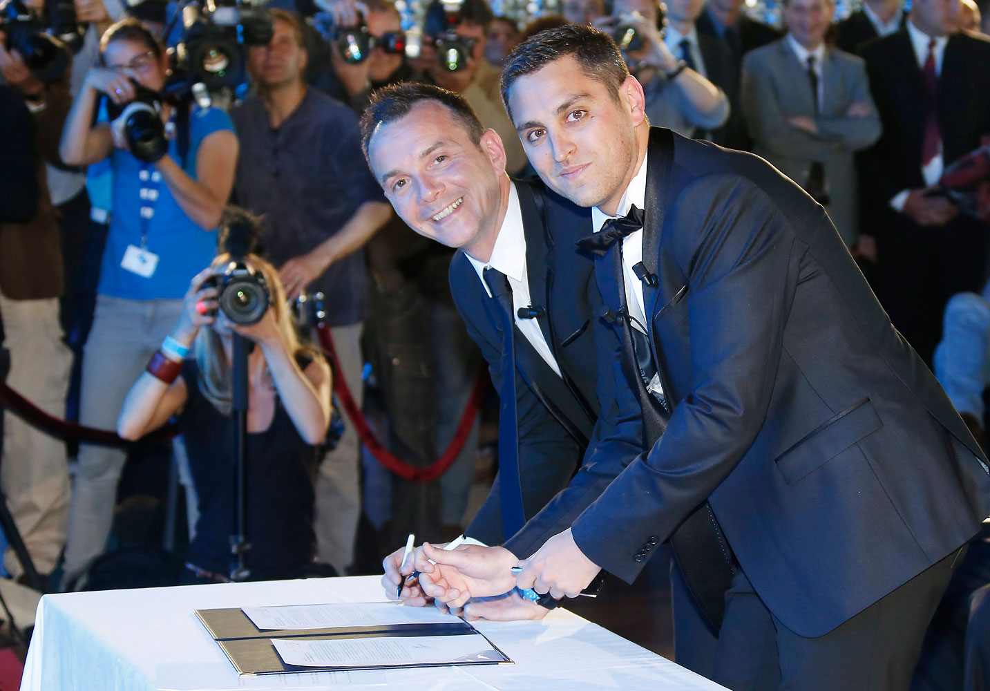 Vincent Autin (L) and his partner Bruno Boileau (R) sign a document during their marriage in Montpellier, southern France on May 29, 2013.