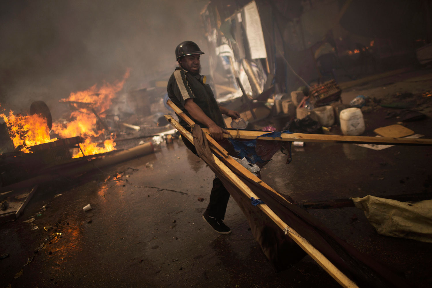 A supporter of ousted Islamist President Mohammed Morsi carries woods to burn in a fire barricade at the sit-in at Rabaa Al-Adawiya square in Cairo's Nasr City district, Aug. 14, 2013.