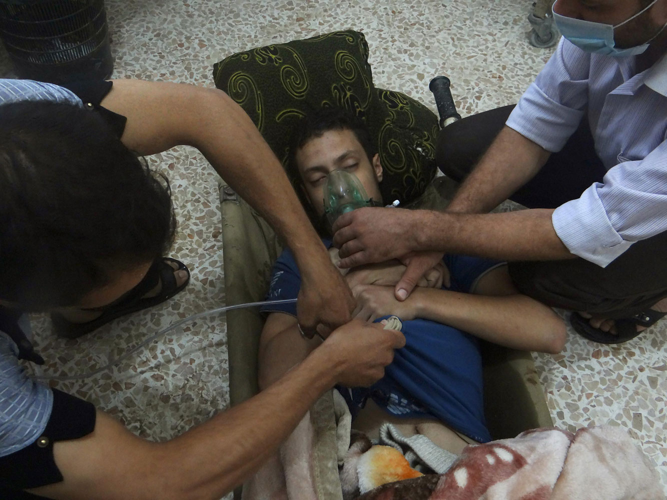 A man, affected by what activists say is nerve gas, breathes through an oxygen mask in the Damascus suburbs of Jesreen, August 21, 2013.