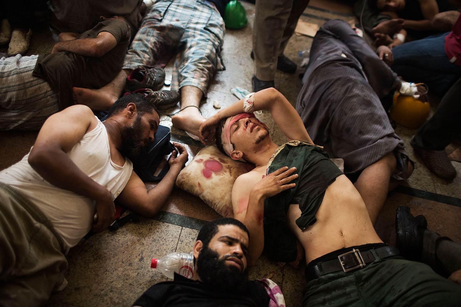 Wounded supporters of ousted Islamist President Mohammed Morsi lie on the floor of a makeshift hospital at a sit-in at Cairo's Nasr City district, Egypt, Aug. 14, 2013.