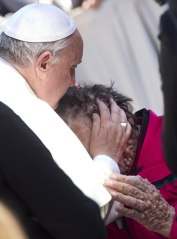 Pope Francis caresses a sick person in Saint Peter's Square at the end of his General Audience in Vatican City, Nov. 6, 2013.