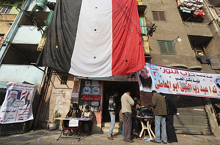 Supporters of parliamentary candidate El Maty of the Salafi party Al-Nour talk to people outside a polling station during parliamentary elections in Cairo