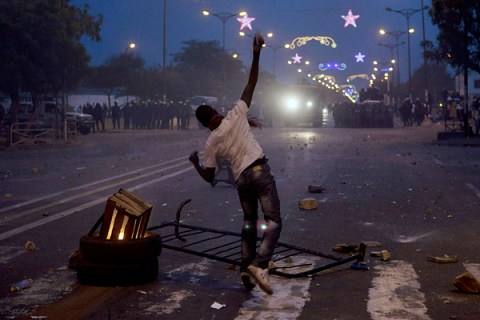 An anti-government demonstrator throws rocks at the police during a protest against Senegal's President Abdoulaye Wade in the capital Dakar