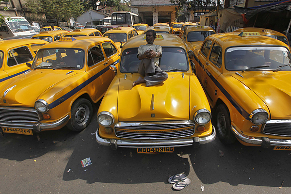 A driver rests on his iconic yellow ambassador taxi during a country-wide strike in the eastern Indian city of Kolkata