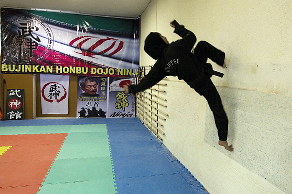 A Ninjutsu practitioner runs up a wall 