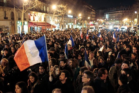 People hold French flags as they attend a silent march in Paris to pay tribute to the four victims killed by a gunman at a Jewish school