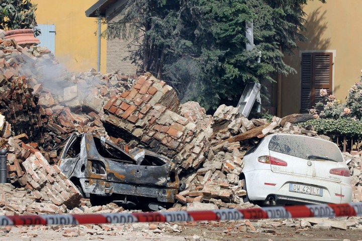 Destroyed cars are seen in the rubble after an earthquake in Finale Emilia