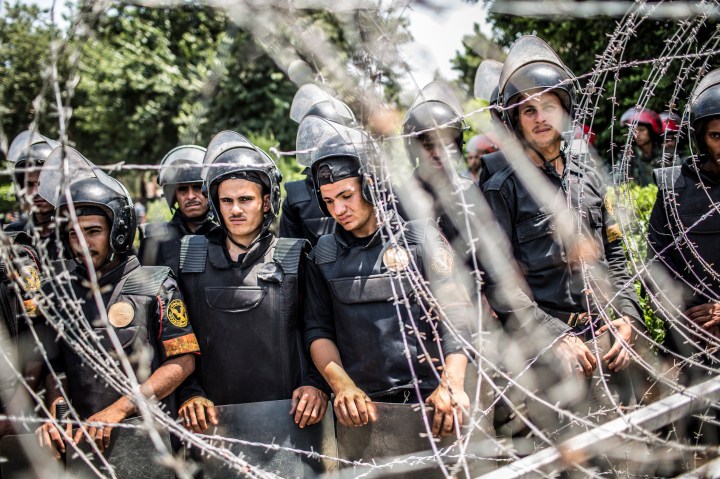 image: Egyptian military police form a barricade during a protest against presidential candidate Ahmed Shafiq outside the Supreme Constitutional Court on June 14, 2012 in Cairo.