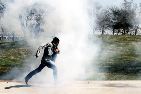 A Kurdish protester clashes with Turkish