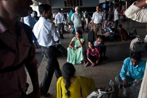 Indian passengers wait for their train a