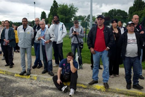 Workers of French carmaker PSA Peugeot Citroen demonstrate in front of the factory in Aulnay-sous-Bois, north of Paris, Thursday, July 12, 2012.