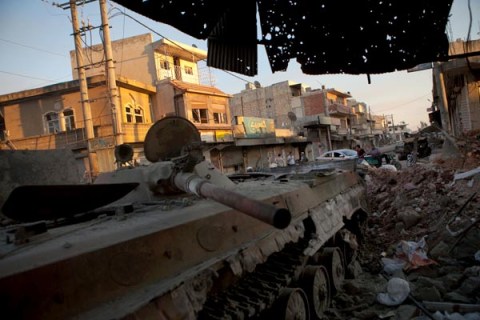 A destroyed Syrian forces tank remains in a damaged street in Atareb in northern Aleppo province on July 2, 2012.