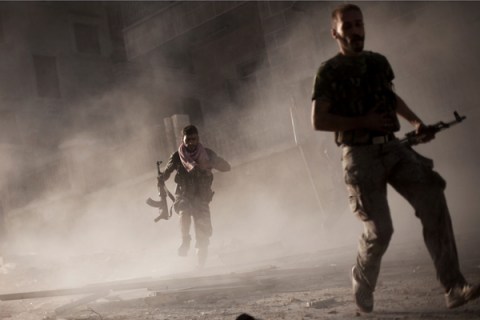 Free Syrian Army fighters run after attacking a Syrian Army tank during fighting in  Aleppo, Syria on Sept 7, 2012. 
