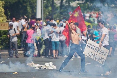 Protester throws a gas cannister
