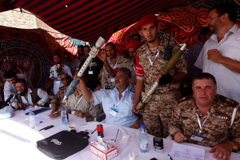 Members of the Libyan military hold weapons and ammunition handed over to them by civilians in Tripoli's Martyrs' Square