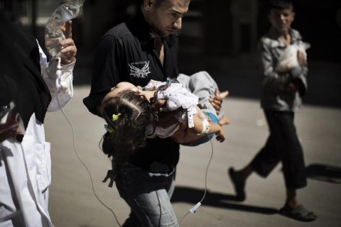 A Syrian man carries his wounded daughter outside a hospital in the northern city of Aleppo on September 18, 2012.