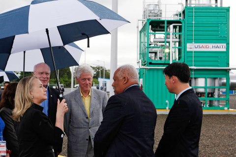 image: From left: U.S. Secretary of State Hillary Clinton is joined by U.S. Senator Pat Leahy, and her husband, former U.S. president Bill Clinton while receiving a briefing about a new power plant during their visit to Caracol, Haiti, on Oct. 22, 2012. 