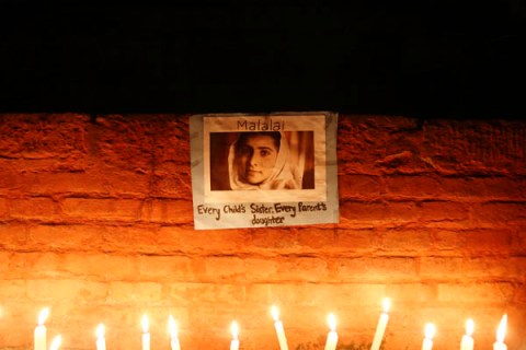 Candles are lit in front of portrait of Pakistani schoolgirl Yousafzai