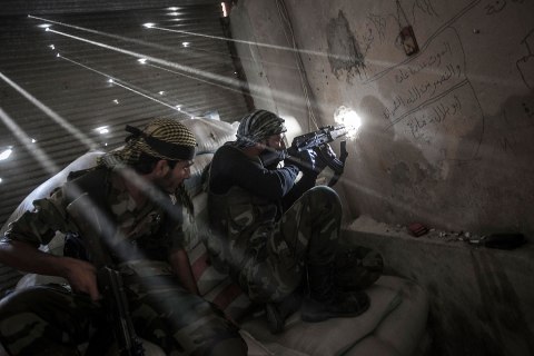image: Rebel fighters belonging to the Javata Harria Sham Qatebee watch over the enemy position during skirmishes at the first line of fire in Karmal Jabl neighborhood, district of Arkup, Aleppo, Oct. 21, 2012.