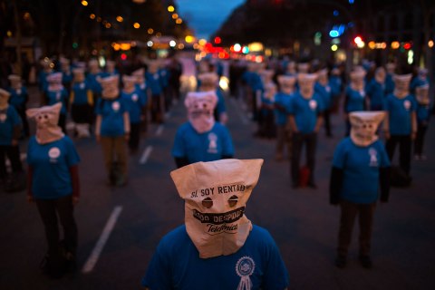image: Workers from Telefonica phone company take part in a demonstration blocking the traffic and protesting against the unjustified dismissals at their company ahead of a general strike in Barcelona, Nov. 13, 2012. 