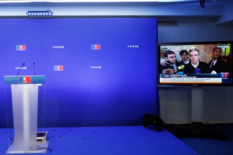 image: An empty podium is seen at the headquarters of the UMP politial party in Paris as a news programme airs an interview with former prime minister Francois Fillon on a large-screen television after the closing of the polls Nov. 18, 2012. 