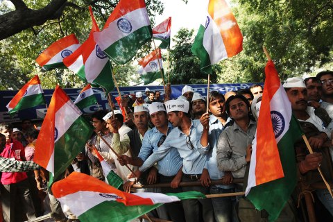 image: Supporters of Indian anti-corruption activist Arvind Kejriwal hold Indian flags as they listen to a speaker at the parliament street in New Delhi, Nov. 26, 2012. 