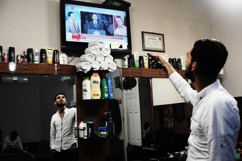 image: A barber watches the results of the U.S. presidential election in Istanbul, Nov. 7, 2012.