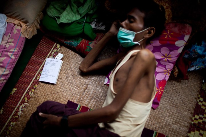 An HIV patient who is also infected with tuberculosis rests on a bed near his pills at an HIV/AIDS center on the outskirts of Yangon, Myanmar. 