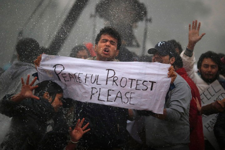 image: Protesters react as Indian police officers use a water cannon to disperse them near the India Gate as they protest against the gang rape and brutal beating of a 23-year-old student on a bus last week, in New Delhi on Dec. 23, 2012.