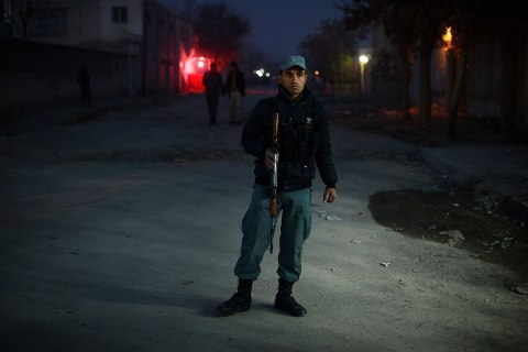 image: An Afghan policeman stands guard near the site of a Taliban sucide bomber attack at a spy agency guesthouse in Kabul, Dec. 6, 2012. 