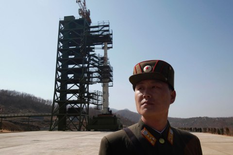 image: A soldier stands guard in front of a rocket sitting on a launch pad at the West Sea Satellite Launch Site, during a guided media tour by North Korean authorities in the northwest of Pyongyang, April 8, 2012.