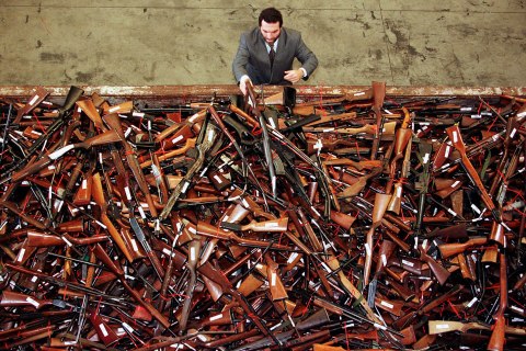 image: Mick Roelandts, firearms reform project manager for the New South Wales Police, looks at a pile of about 4,500 prohibited firearms in Sydney that have been handed in over the past month under the Australian government's buy-back scheme, July 28, 1997.