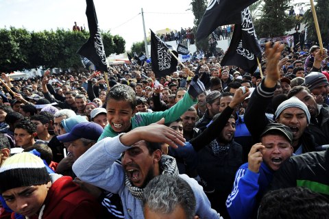 image: Inhabitants of Sidi Bouzid wave black religious flags and shout slogans calling for Tunisia's President Moncef Marzouki to leave in Sidi Bouzid, Dec. 17, 2012.
