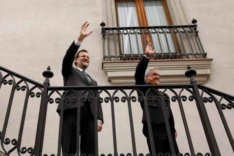 Chile's President Pinera and Spain's PM Rajoy wave to the media at the La Moneda Presidential Palace in Santiago