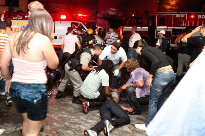 A policeman and rescue workers help a man at the scene of a fire at Boate Kiss nightclub in the southern city of Santa Maria, Brazil, Jan. 27, 2013. 