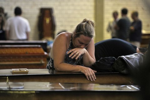The relative of a victim of the the Boate Kiss nightclub fire mourns over a coffin in Santa Maria, Brazil, Jan. 27, 2013.