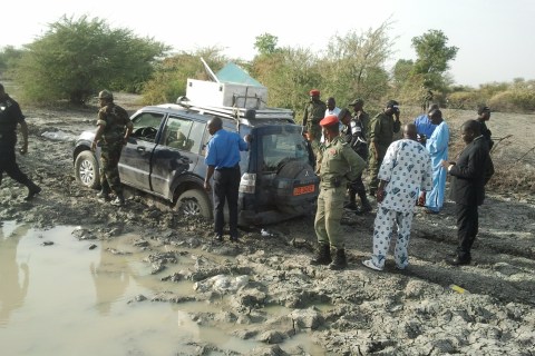 Policemen gather around a vehicle that carried seven members of a family kidnapped in Cameroon.