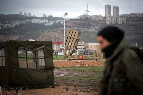 An Israeli soldier walks by an 'Iron Dome' short-range missile defense system positioned near the northern city of Haifa on Jan. 31, 2013 in Israel. The Iron Dome missile defense system is designed to intercept and destroy incoming short-range rockets and artillery shells.
