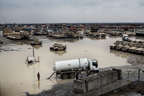 Civilian contractors work to drain a large puddle following a winter rain at Bagram Airbase, Afghanistan, Jan. 31, 2013.