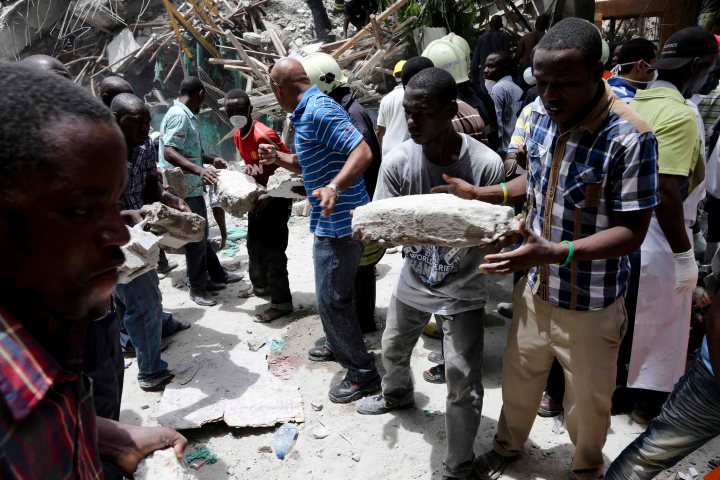 Local residents clean up the building collapse site in downtown of Dar es Salaam, Tanzania on March 29, 2013.
