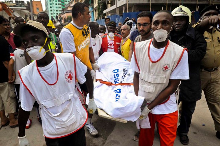 Rescuers from the Tanzania Red Cross carry away a body from the rubble of a collapsed building in downtown Dar es Salaam, Tanzania on March 29, 2013. 
