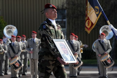 A soldier holds a portrait of late French paratrooper Imad Ibn Ziaten, the first victim of Islamist gunman Mohamed Merah, on March 11, 2013 in Toulouse, during a ceremony awarding him with the Legion d'Honneur.