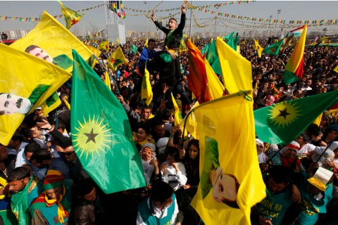 Demonstrators hold Kurdish flags and portraits of jailed Kurdistan Workers Party leader Abdullah Ocalan during a gathering to celebrate Newroz in the southeastern Turkish city of Diyarbakir on March 21, 2013. 