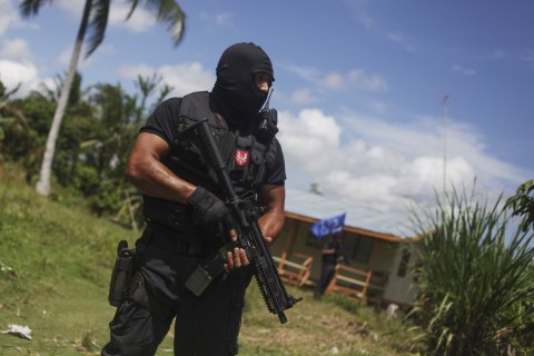 A member of the Malaysian Special Forces Unit stands guard as a standoff continues between the Malaysian police and an armed group of Filipinos in Kampung Senallang Lama, Malaysia, March 13, 2013. 