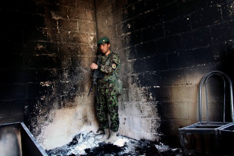 An Afghan army soldier stands guard in the destroyed courthouse in Farah, western Afghanistan, April 4, 2013.