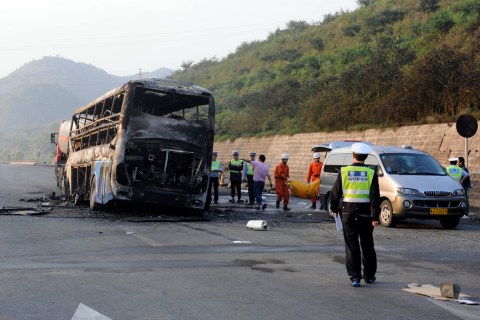 Police and rescuers remove the bodies from a burnt out double-decker sleeper bus after a collision with a tanker near Yanan in northern China's Shaanxi province on Aug., 26, 2012.
