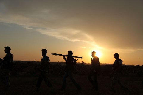 Syrian rebels walk to reposition near Mena airport, in Aleppo, Syria, on May 22, 2013.