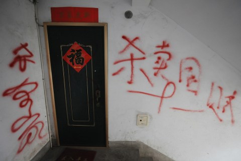 Grafitti saying "Kill everyone in the home" and "Kill traitors" painted outside the family home of Chinese student Grace Wang in the city of Qingdao on April 21, 2008.