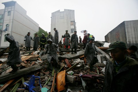Soldiers of the People's Liberation Army search for victims among debris following an earthquake on May 13, 2008 in Dujiangyan of Sichuan Province, China.