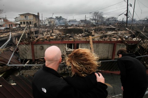 Robert Connolly, left, embraces his wife Laura as they survey the remains of the home owned by her parents that burned to the ground in the Breezy Point section of New York, Oct. 30, 2012.